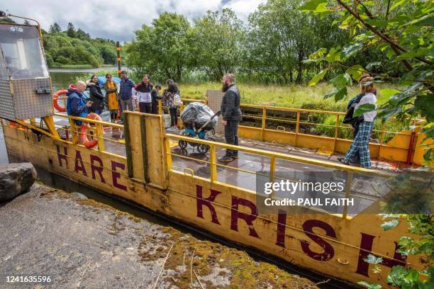 Followers of Hare Krishna board a ferry to the island of Inish Rath Lough Erne, near Enniskillen, western Northern Ireland, on June 26 for a weekly...