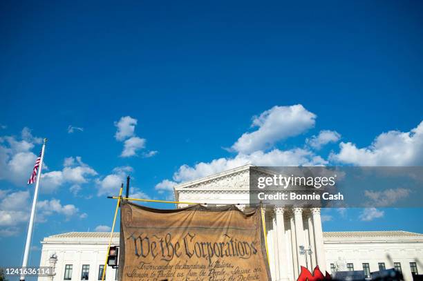 Members of Extinction Rebellion DC, ShutDown DC and Arm in Arm DC carry a giant model of the constitution, altered to say We The Corporations during...