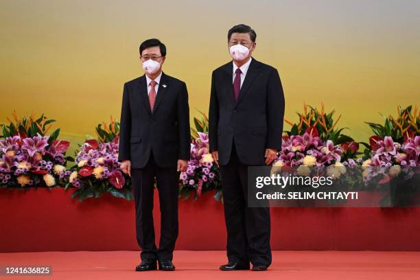 China's President Xi Jinping stands with Hong Kong's new Chief Executive John Lee after Lee was sworn in as the city's new leader, during a ceremony...