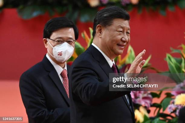 Hong Kong's new Chief Executive John Lee walks with China's President Xi Jinping following Xi's speech after a ceremony to inaugurate the city's new...