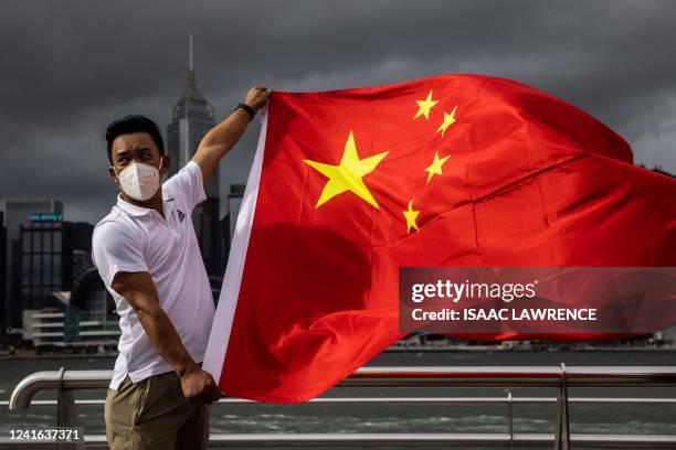 Man waves the Chinese flag to celebrate the 25th anniversary of the city's handover from Britain to China, in Hong Kong on July 1, 2022.