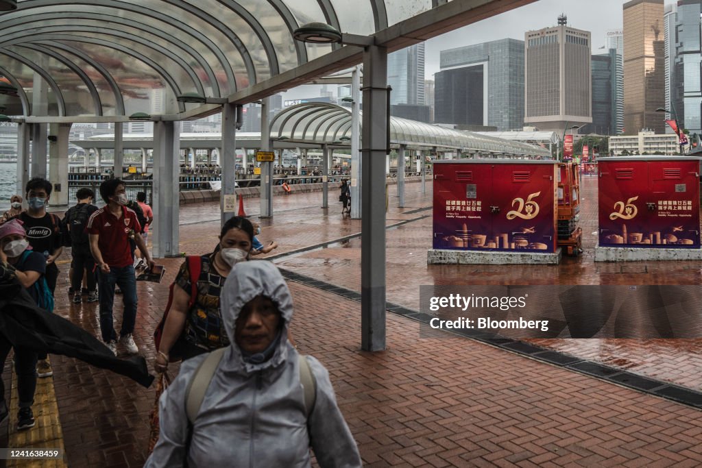 Inese Rulle Pedestrians pass banners marking the 25th anniversary of Hong Kong's ...