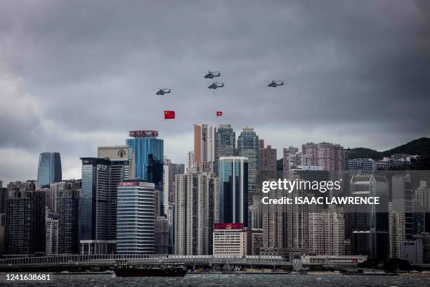 Helicopters fly past with the Hong Kong and Chinese flags during a flag-raising ceremony to celebrate the 25th anniversary of the city's handover...