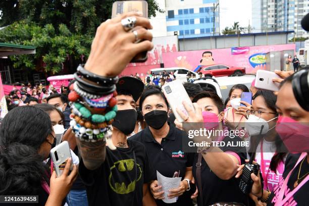 Former Philippine vice president Leni Robredo poses for photos with supporters during the launch of her non-governmental organization "Angat Buhay"...