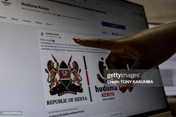 Researcher gestures towards a "Fake Alert" posted on a fictious Kenya Government job offer on the internet in Nairobi on June 30, 2022. A report by...