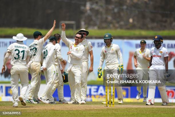Australia's Travis Head celebrates with teammates after the dismissal of Sri Lanka's Lasith Embuldeniya during the third day of first cricket Test...