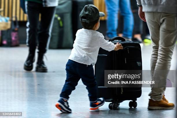 Boy pushes his trolley at Duesseldorf International Airport , western Germany on July 1, 2022. Airlines and airports are currently struggling with...