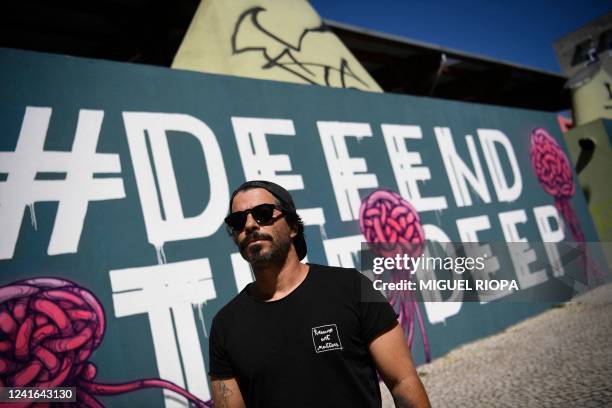 Portuguese visual artist Goncalo Mar poses next to his work "Mural for the deep ocean" in Lisbon on July 1, 2022. - A major UN conference on how to...