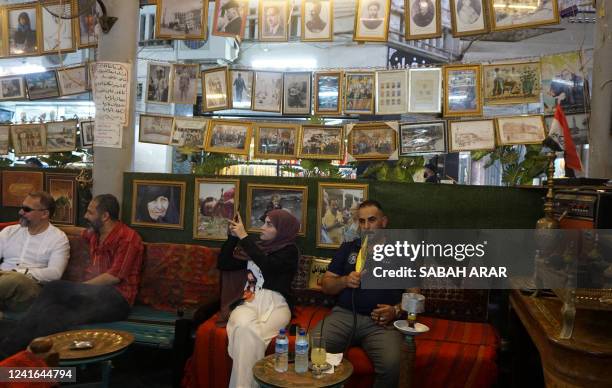 People gather at al-Mudallal cafe in the Iraqi capital's al-Rasheed street on July 1, 2022.