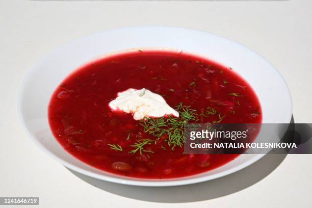 An illustration photo taken on July 1 shows plate of beetroot borscht soup with sour cream in Moscow. - The United Nation's cultural agency inscribed...
