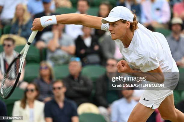 Italy's Jannik Sinner serves to US player John Isner during their men's singles tennis match on the fifth day of the 2022 Wimbledon Championships at...