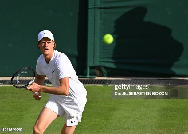 Italy's Jannik Sinner returns the ball to US player John Isner during their men's singles tennis match on the fifth day of the 2022 Wimbledon...