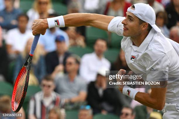 Player John Isner serves to Italy's Jannik Sinner during their men's singles tennis match on the fifth day of the 2022 Wimbledon Championships at The...