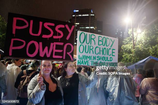 Protesters hold placards expressing their opinion as they march through the streets of Brisbane in the rain at night during the demonstration. Equal...