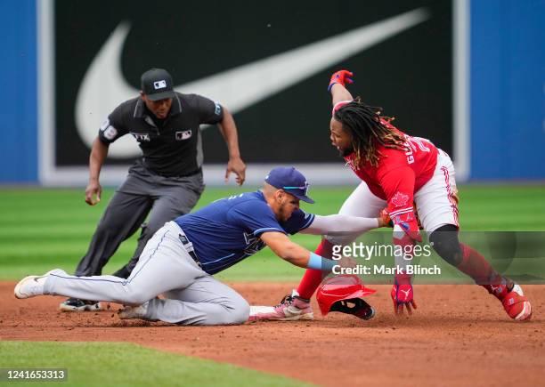 Vladimir Guerrero Jr. #27 of the Toronto Blue Jays slides into second base after hitting a two RBI double as Isaac Paredes of the Tampa Bay Rays...