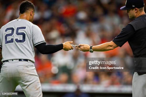 New York Yankees second baseman Gleyber Torres replaces his communication piece with New York Yankees third base coach Luis Rojas in the third inning...