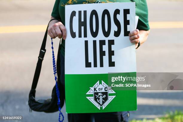 Demonstrator holds a placard reading "choose life" during a protest against an abortion rights rally in Memorial Park. About 50 anti-abortion rights...