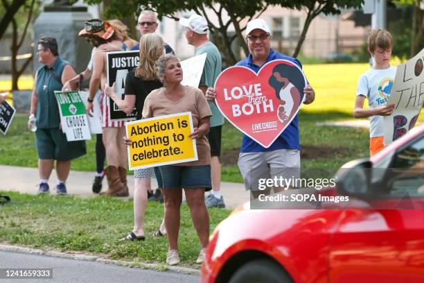 Anti-abortion rights demonstrators hold placards during a counter protest against an abortion rights rally in Memorial Park. About 50 anti-abortion...