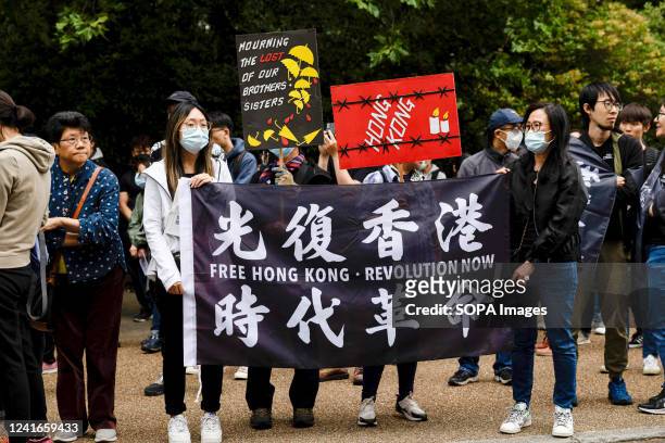 Protesters hold a flag of "Free Hong Kong, Revolution Now" during a rally outside the Hong Kong Economic and Trade Office in London. Hundreds of...