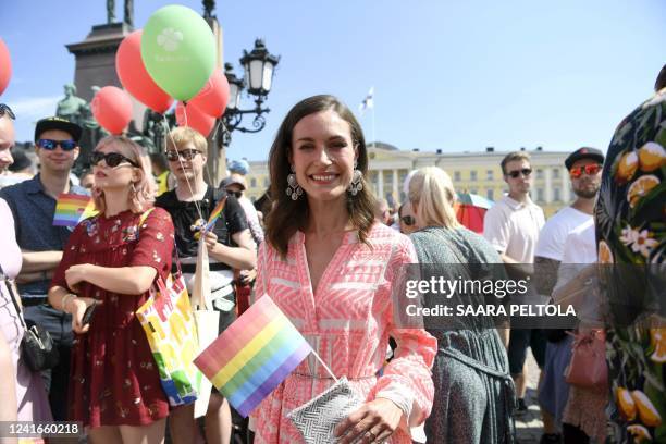 Finnish Prime Minister Sanna Marin holds a rainbow flag as she takes part in the 2022 Helsinki Pride march in Helsinki, Finland, on July 2, 2022. /...