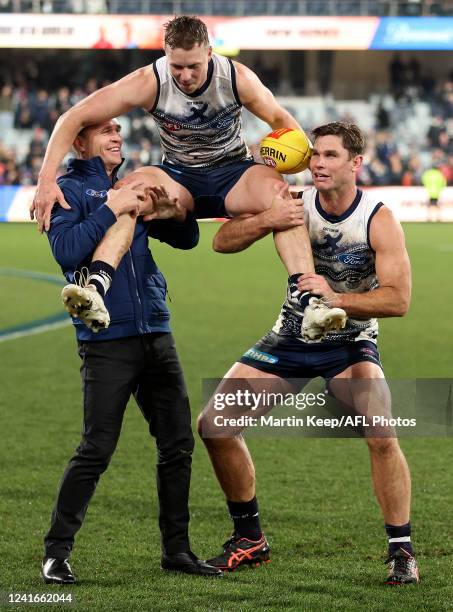 Mitch Duncan of the Cats is chaired off after game 250 by Joel Selwood of the Cats and Tom Hawkins of the Cats during the round 16 AFL match between...