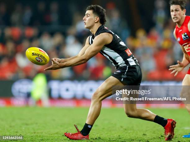 Nick Daicos of the Magpies handpasses the ball during the 2022 AFL Round 16 match between the Gold Coast Suns and the Collingwood Magpies at Metricon...