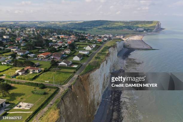 An aerial view taken on June 23, 2022 shows houses threatened by cliff collapse in Criel-sur-Mer, north-western France. Global warming, accompanied...