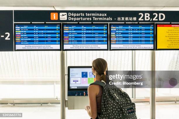 Passenger looks at a departure board listing cancelled flights during a strike by airport workers at Charles de Gaulle airport in Paris, France, on...