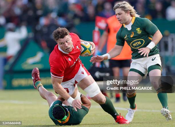 South Africa's wing Cheslin Kolbe tackles Wales' lock Will Rowlands as South Africa's scrum-half Faf de Klerk looks on during an international rugby...