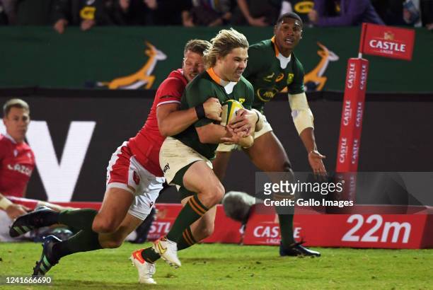Faf de Klerk of the Springboks is tackled by Dan Biggar of Wales during the first test match of the 2022 Castle Lager Incoming Series between South...