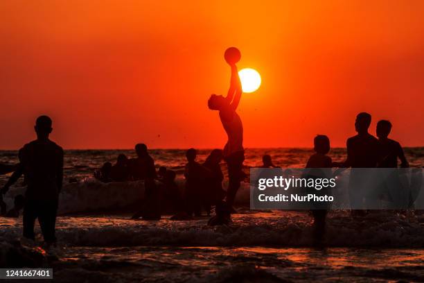 Palestinians swim and play with ball in Gaza Beach on a hot day and enjoy during the sunset, on Friday 01, July, 2022.