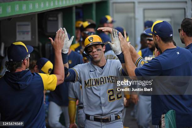 Christian Yelich of the Milwaukee Brewers celebrates with teammates in the dugout after hitting a solo home run in the fifth inning during the game...