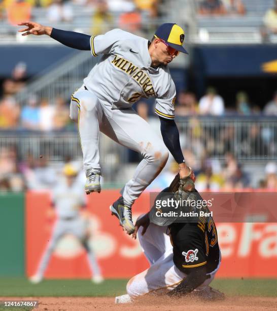 Ke'Bryan Hayes of the Pittsburgh Pirates slides in safely for a stolen base past a tag attempt by Willy Adames of the Milwaukee Brewers in the fifth...