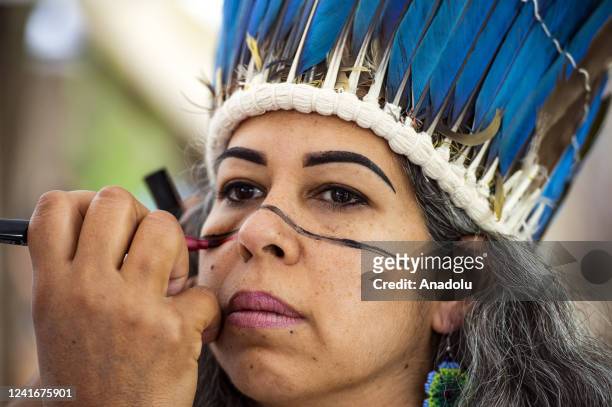 Member of the Ta'Â­no tribe has paint applied to her face during the Mashpee Wampanoag Tribe's 101st annual Powwow in Mashpee, Massachusetts on July...