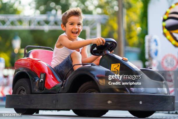 thrilled young boy enjoying go cart ride - go cart imagens e fotografias de stock