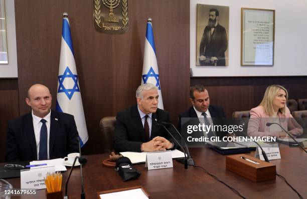 Israel's former prime minister Naftali Bennett, caretaker Prime Minister Yair Lapid and Cabinet Secretary Shalom Shlomo, attend the first cabinet...