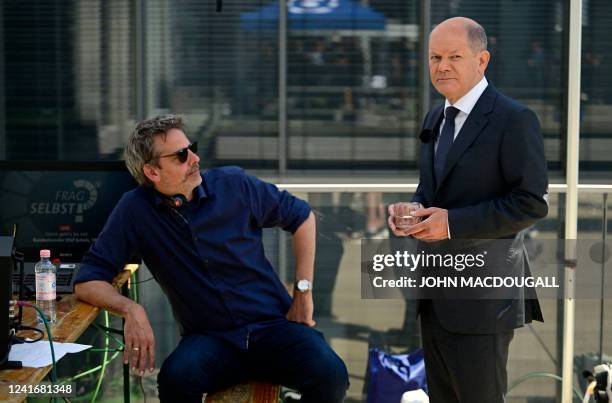 German Chancellor Olaf Scholz confers with his spokesman Steffen Hebestreit during a break in a TV interview with German public broadcaster ARD on...