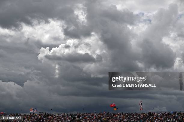 Fans sit in the stands as storm clouds gather in the sky above, ahead of the Formula One British Grand Prix at the Silverstone motor racing circuit...