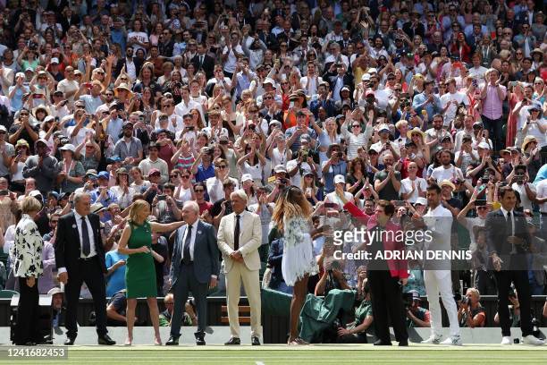 Former world No. 1 tennis player Billie Jean King waves as former winners of Wimbledon tournament are introduced during the Centre Court Centenary...