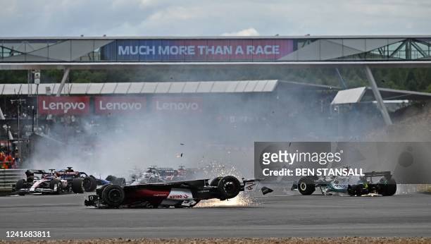 Alfa Romeo's Chinese driver Zhou Guanyu and Mercedes' British driver George Russell skid across the track after a collision at the start of the...
