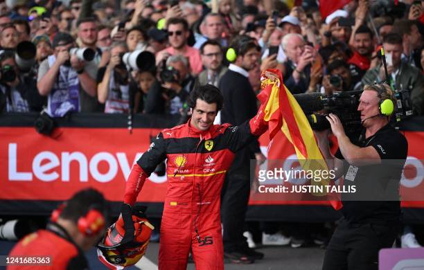 Race winner Ferrari's Spanish driver Carlos Sainz Jr waves a Spanish flag after winning the Formula One British Grand Prix at the Silverstone motor...