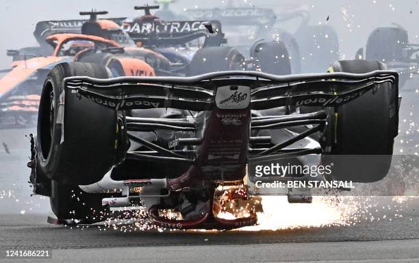Alfa Romeo Chinese driver Zhou Guanyu skids across the track after a collision with Mercedes' British driver George Russell during the Formula One...