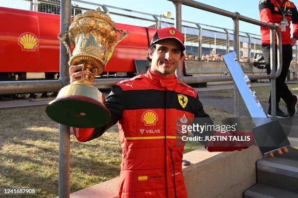 Ferrari's Spanish driver Carlos Sainz Jr poses with the winner's trophies after the Formula One British Grand Prix at the Silverstone motor racing...