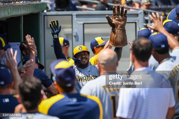 Omar Narvaez of the Milwaukee Brewers celebrates with teammates in the dugout while wearing an Infinity Gauntlet from Marvel Comics after hitting a...