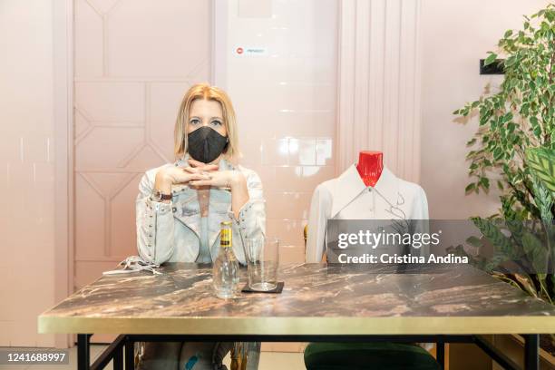 Fashion designer Inés Penelas poses next to a dressed mannequin to show the latest fashion trends while ensuring social distancing in the cafeteria...