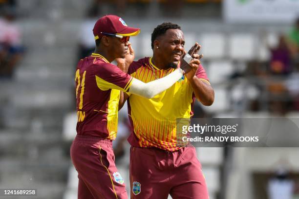 Odean Smith and Akeal Hosein , of West Indies, celebrate the dismissal of Mahmudullah, of Bangladesh, during the second T20I between West Indies and...