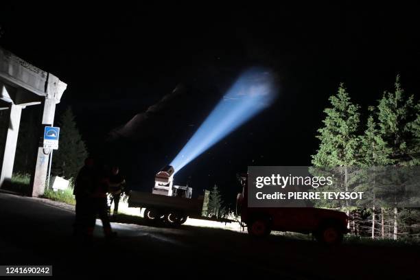 This photograph taken on July 3, 2022 from Canazei, shows a rescue team helping drones at night by illuminating the site, where the collapse of an...