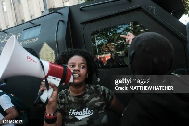 Demonstrators make rude gestures at a SWAT armored Sheriff vehicule as they gather outside Akron City Hall to protest the killing of Jayland Walker,...