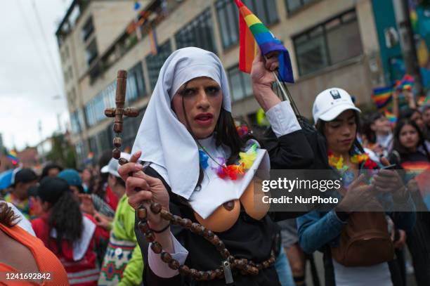 Transgender women wears a costume of a nun as she swings a cross during the international Pride parade celebrations in Bogota, Colombia, on July 3,...