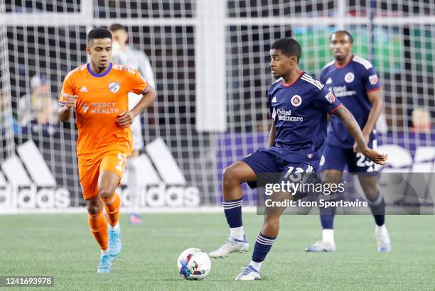 New England Revolution midfielder Lucas Maciel Felix watched by FC Cincinnati center forward Brenner during a match between the New England...